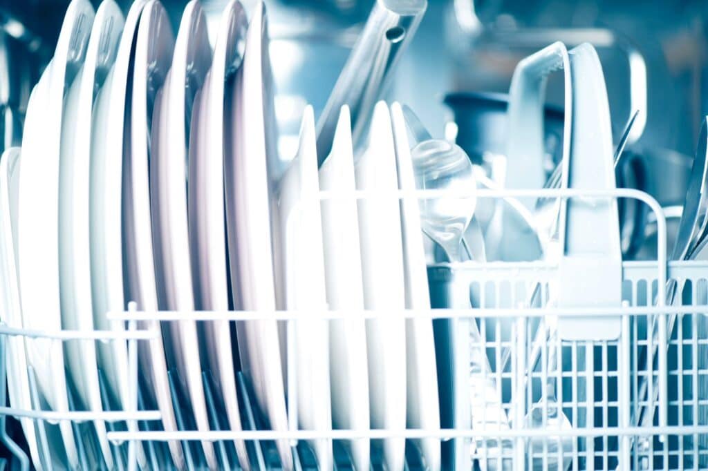 Dinnerware inside an opened dishwasher